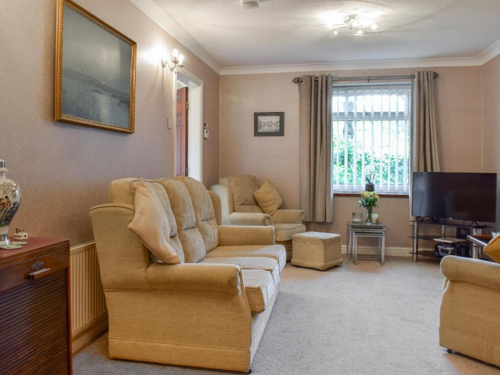 a living room with a couch and a tv at Swallow Cottage - Uk49756 in Little Singleton