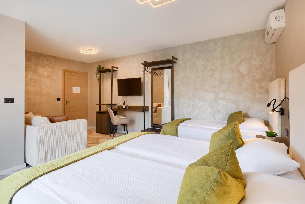 a hotel room with two beds and a television at Pula City Center Accommodation - Breakfast included in Pula