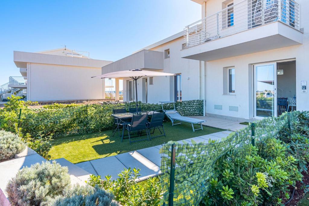 une maison avec un patio avec une table et des chaises dans l'établissement I Due Mori Marzamemi, à Marzamemi
