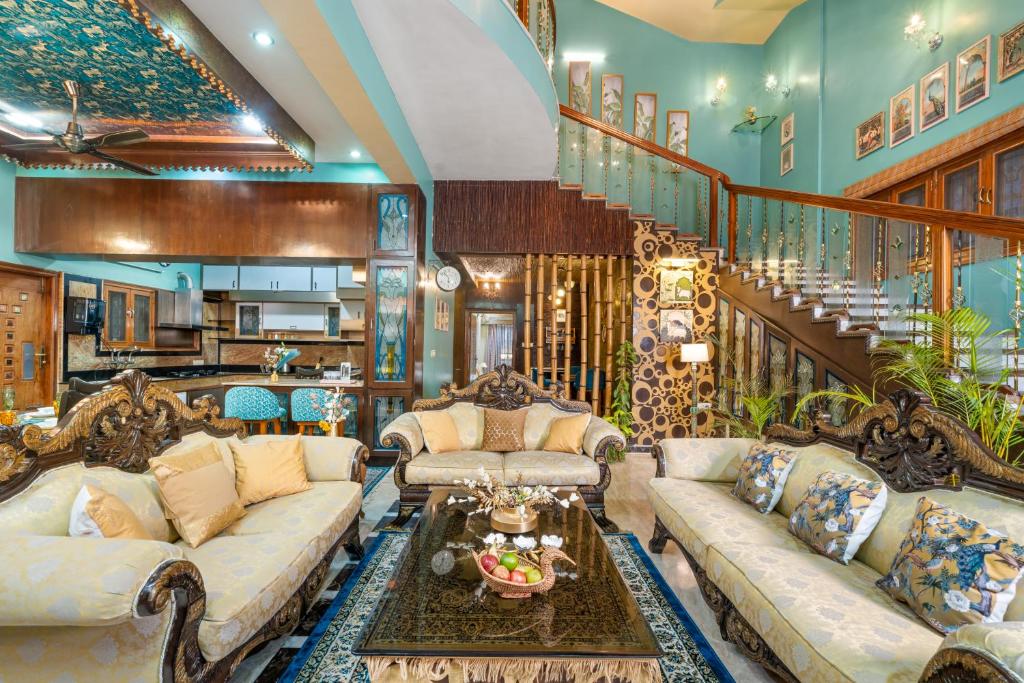 een grote woonkamer met banken en een trap bij Wooden Whispers Traditional Luxe Spacez Villa in Bangalore