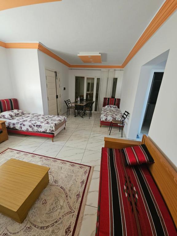 a living room with two beds and a table at Dartoumana Ogla Zarzis EL Bahia in Sangho