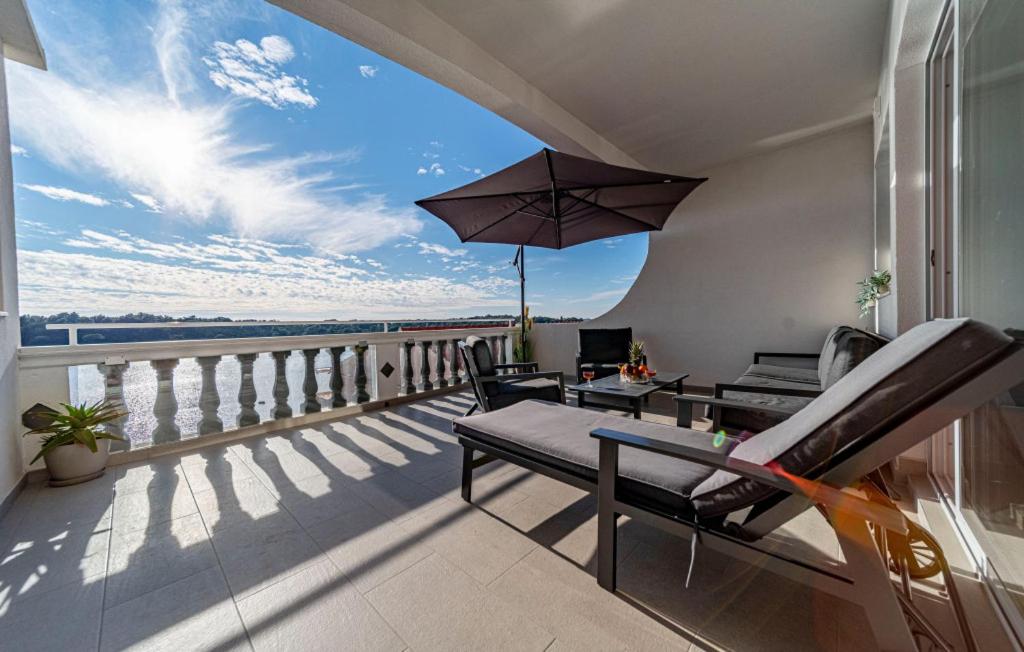 a balcony with a table and chairs and an umbrella at Apartment President by Villas Guide in Brnistrova