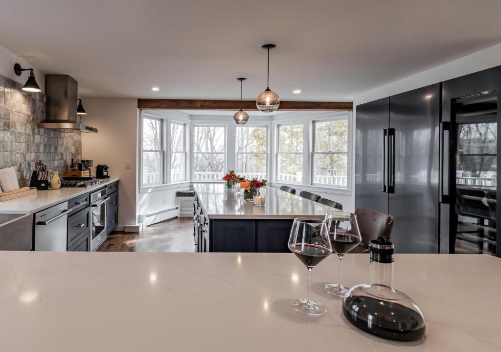 a kitchen with two wine glasses on a counter at The Old Bell Tavern - Luxury Meets History in New Gloucester