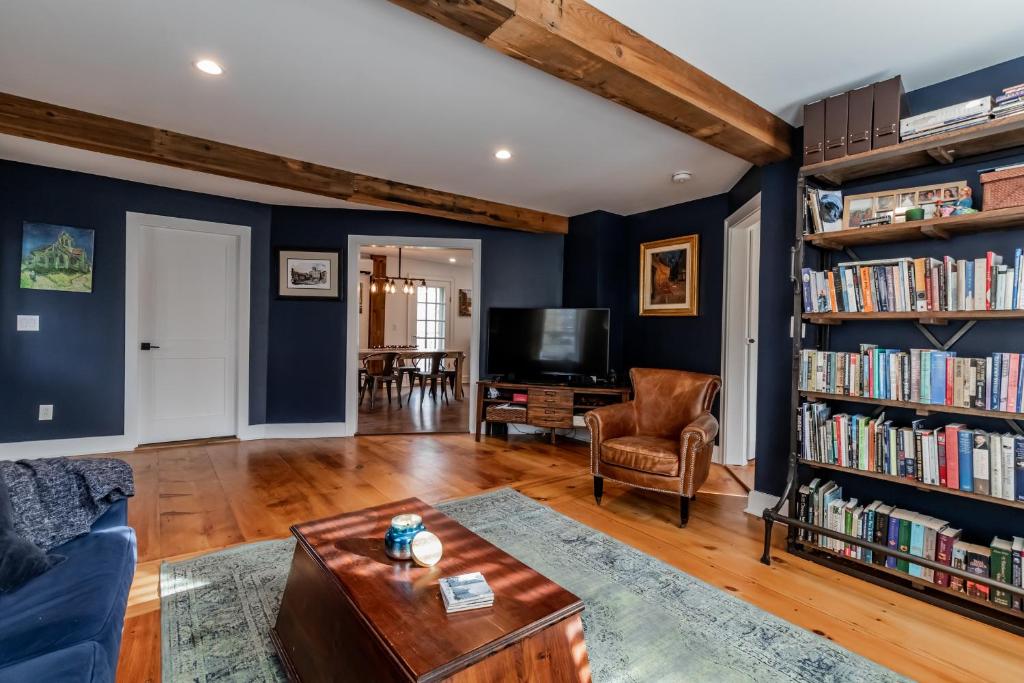 a living room with blue walls and a book shelf at The Old Bell Tavern - Luxury Meets History in New Gloucester