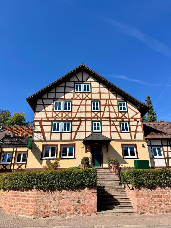 a large building with a staircase in front of it at Boardinghouse Zur Rose in Leidersbach
