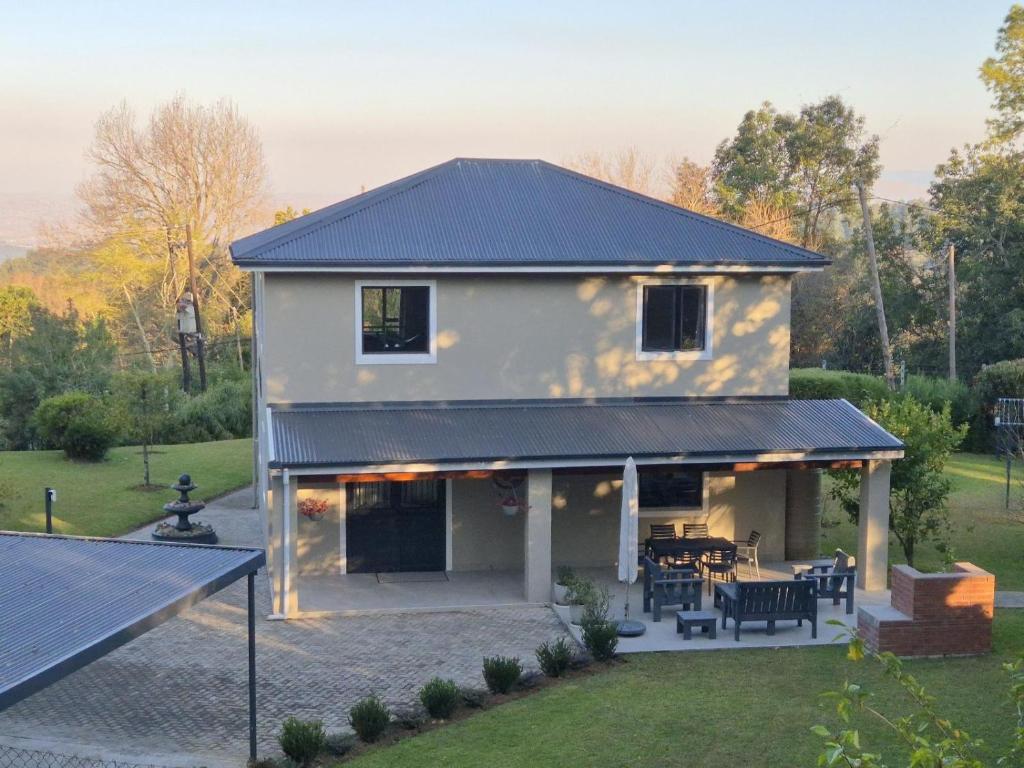 ein Haus mit einem schwarzen Dach und einer Terrasse in der Unterkunft Courtleigh Cottage in Hilton