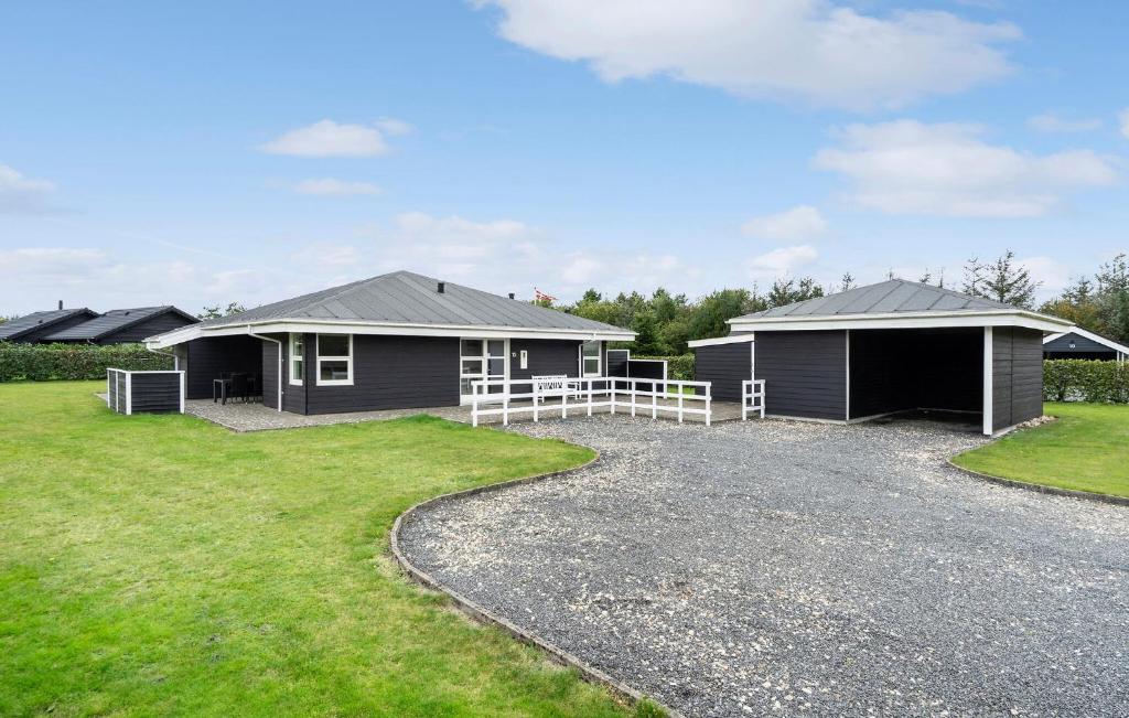 a group of houses with a gravel driveway at Nice Home In Tarm With Sauna in Højsand