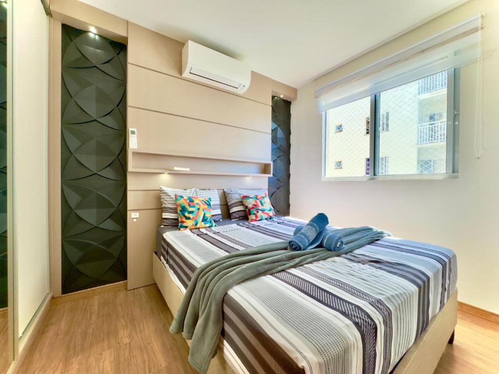 a bedroom with a bed and a window at Apto completo com VISTA MAR em CONDOMINIO RESORT FRENTE MAR em Barra Velha 2 quartos AR CONDICIONADO CHURRASQUEIRA privativa Cozinha Completa PISCINA vaga de Garagem - VIL3 in Barra Velha