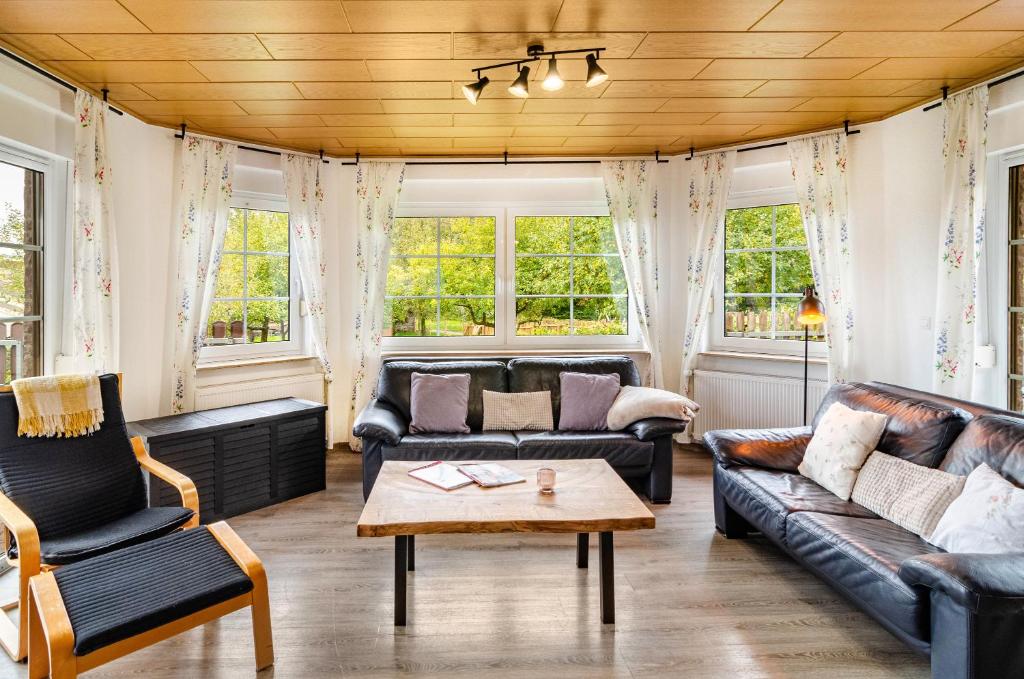 una sala de estar con muebles y ventanas de cuero. en Landhaus Hillebrand, en Trendelburg