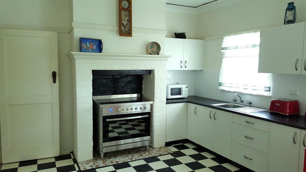 a kitchen with a fireplace and a stove top oven at King Cottage in Windsor