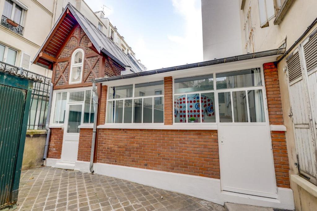 a brick building with a white garage door at The Tour Pavilion - Calm and Bright in Paris