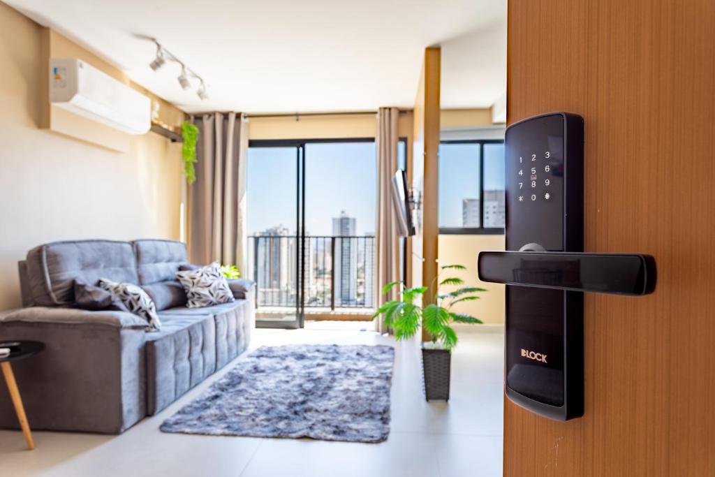 a living room with a couch and a tv at Apt Novo 20º Andar, Perto de Tudo! in Goiânia