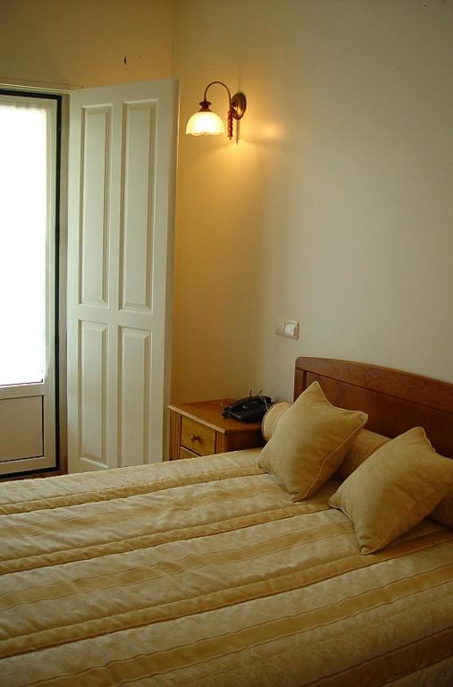 a bedroom with a large bed and a window at Residencial Valinho in Mendiga