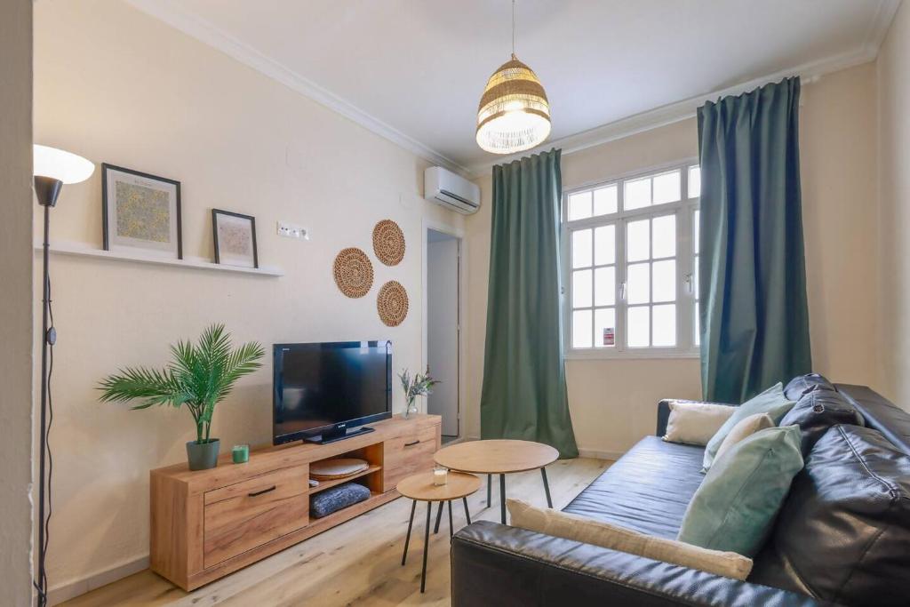 a living room with a couch and a tv at Cadizz Entre Cielo y Mar Centro del Puerto ciudad in El Puerto de Santa María
