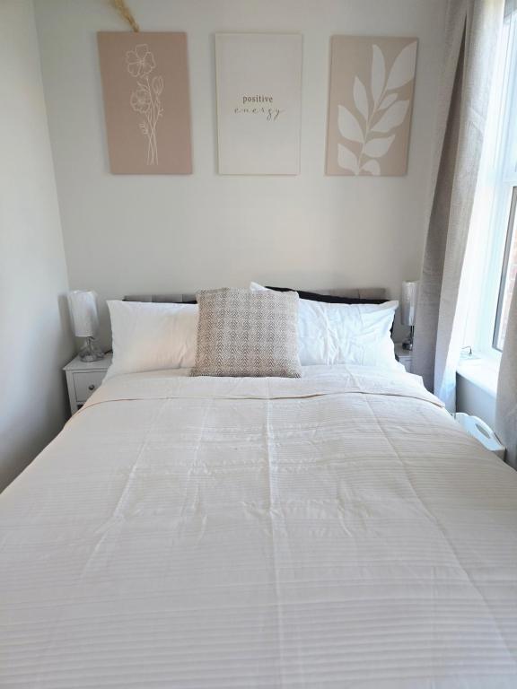 a bedroom with a large bed with white sheets at Sunny in London