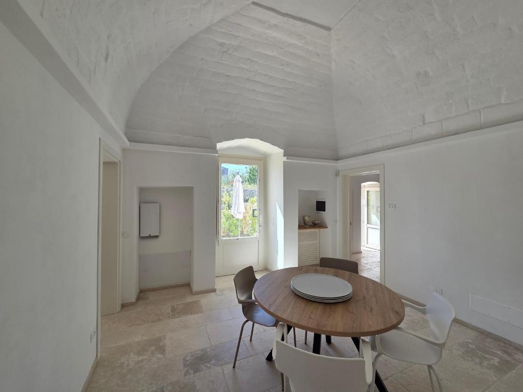 a dining room with a wooden table and chairs at Loco Holiday - Don Rosario in Locorotondo