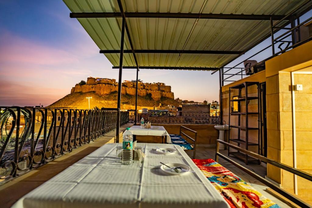 a table on a balcony with a view of a castle at Peace & Joy in Jaisalmer