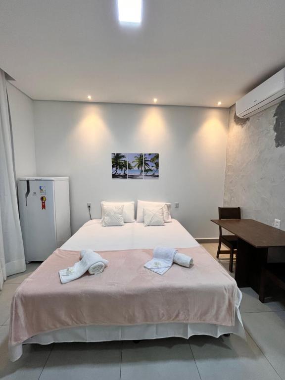 a bedroom with a bed with two towels on it at Vila flores e mar in São Miguel do Gostoso
