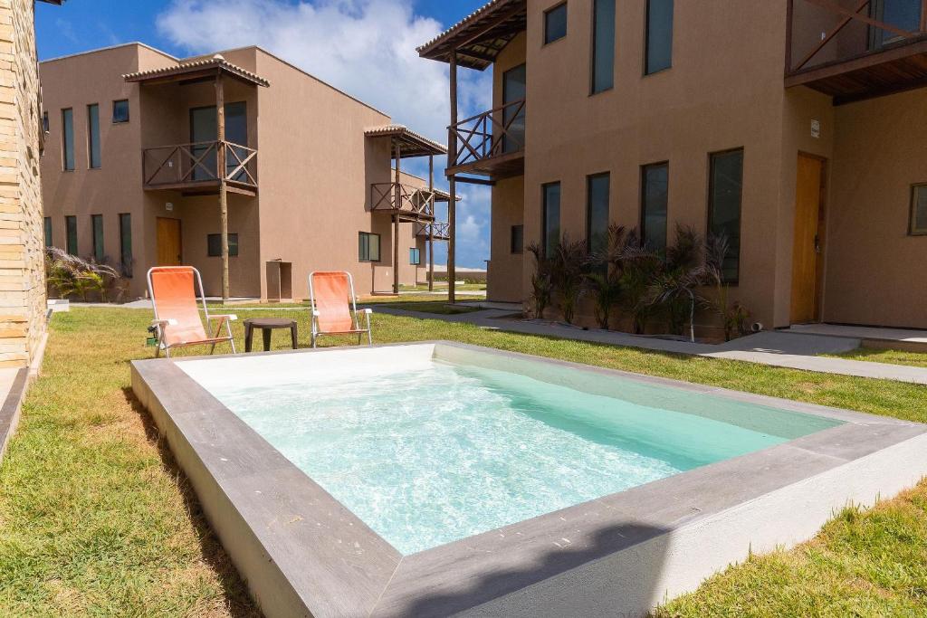 a swimming pool in the backyard of a house at Beachfront Duplex #A6 - Aquiráz By Carpediem in Aquiraz
