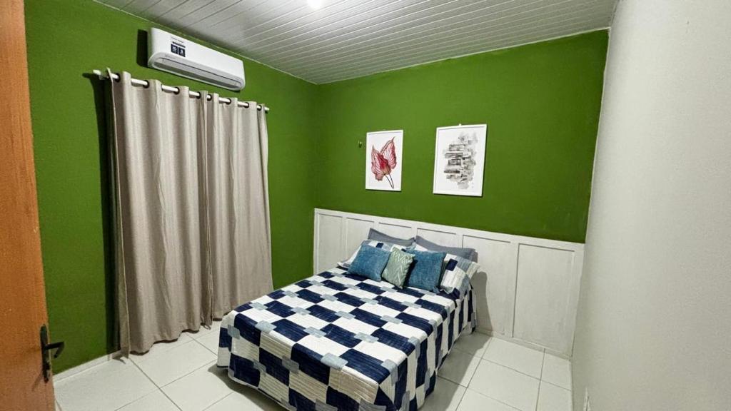 1 dormitorio con paredes verdes y 1 cama. en Casa aconchegante no litoral do Piauí, ao lado da Iesvap e Assaí Supermercado, en Parnaíba
