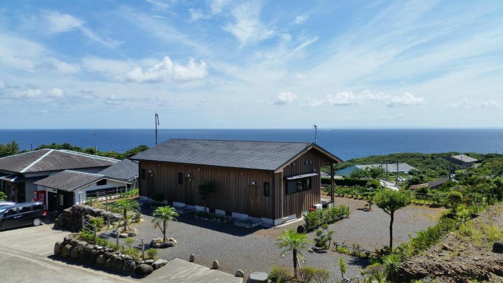 una vista aérea de un edificio con el océano en el fondo en Minnsyuku Yakushimaya, en Yakushima