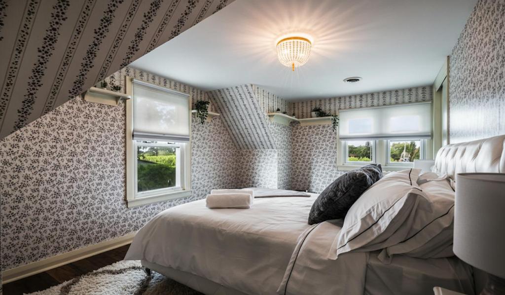 a bedroom with a large bed and two windows at Tiny Home in Balm Beach