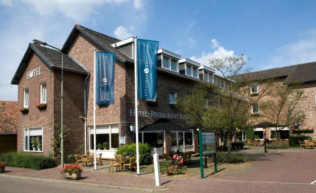 een gebouw met blauwe vlaggen ervoor bij Fletcher Hotel Restaurant Bon Repos in Noorbeek