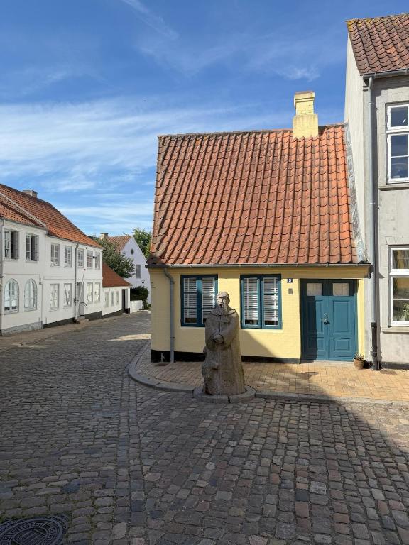 a yellow building with a red roof on a street at Historical Townhouse in Aabenraa