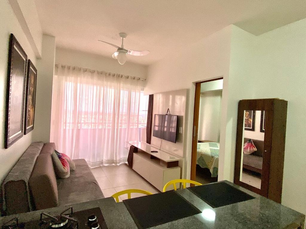 a living room with a couch and a television in a room at Studio Unique 2802 com garagem á 15 min do centro de Belém in Belém