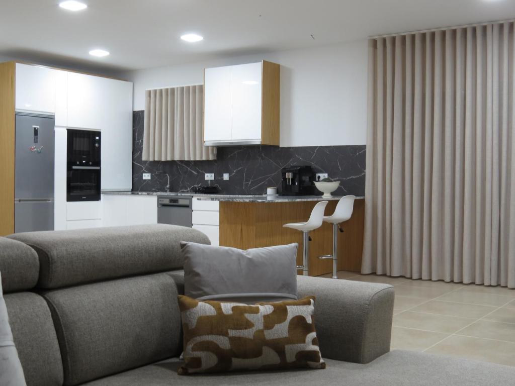 a living room with a couch and a kitchen at Manecas House Creative in Reriz
