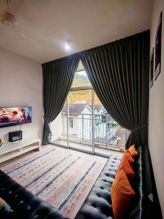 a living room with a couch and a large window at Studio BARRINGTON SQUARE II in Brinchang