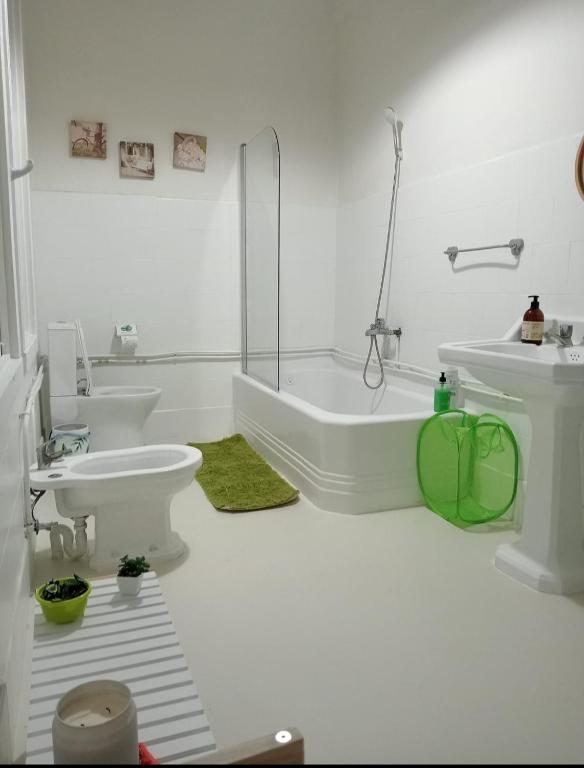 a white bathroom with two sinks and a tub and a toilet at Apartamento Frida se alquila por habitaciones in A Coruña