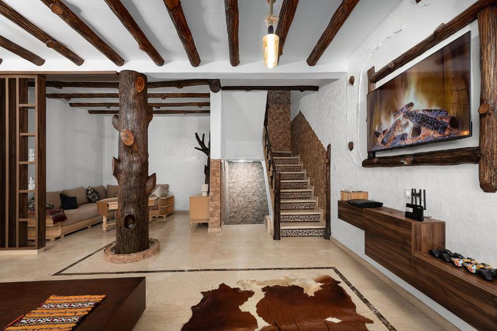 a living room with a tree and a tv at Harhoura Luxury Stay, Steps from the Beach in Temara