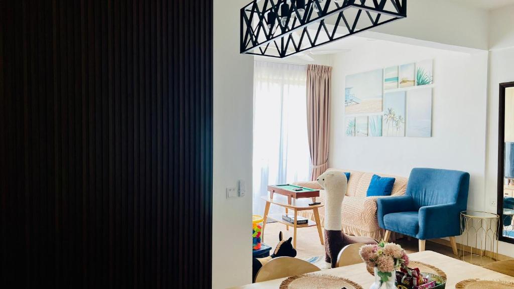 a living room with a blue chair and a table at Mutiara Melaka Beach Resort Condominium,Pantai Puteri Melaka in Malacca