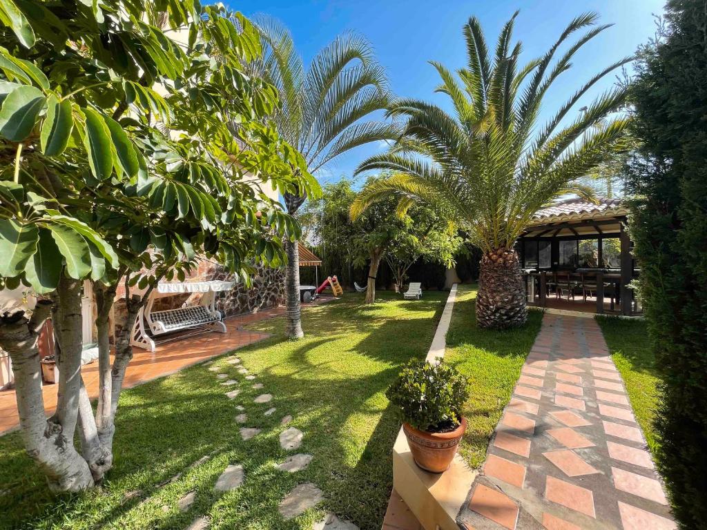 einen Garten mit Palmen und ein Gebäude in der Unterkunft Preciosa Casa Con Jardín Privado in Puerto de la Cruz