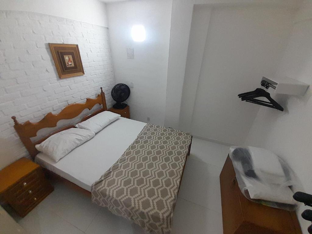 a small bedroom with a bed and a chair at Casa com saída p/ praia do Peró Cabo Frio in Peró