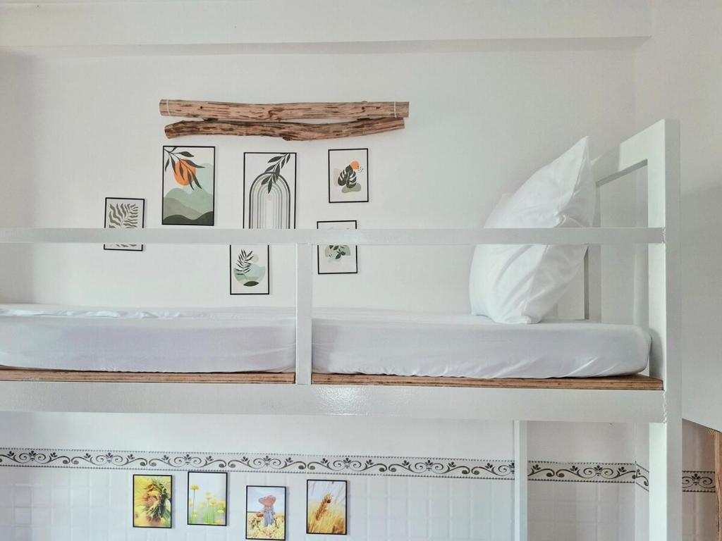 a bedroom with white shelves with pictures on the wall at Tiny house, traditional, friendly neighbour, center, sunset lake view in Can Tho