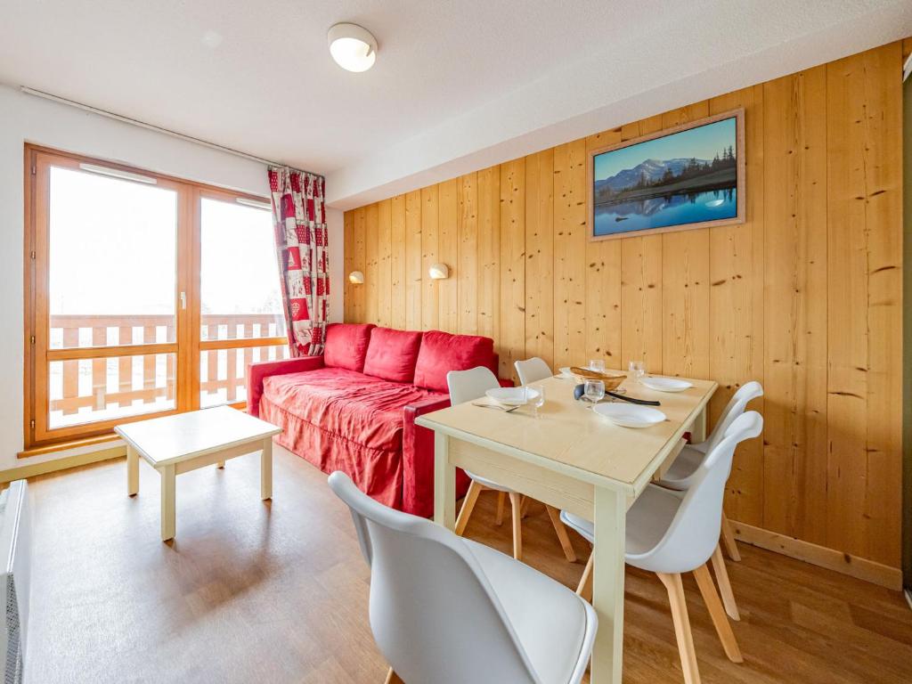 a living room with a table and a red couch at Appartement 6 pers aux pieds des pistes à Saint-François-Longchamp - FR-1-807-29 in Saint-François-Longchamp
