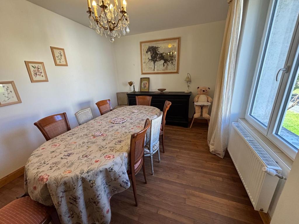 una sala da pranzo con tavolo, sedie e una finestra di Chez Patricia a Graçay