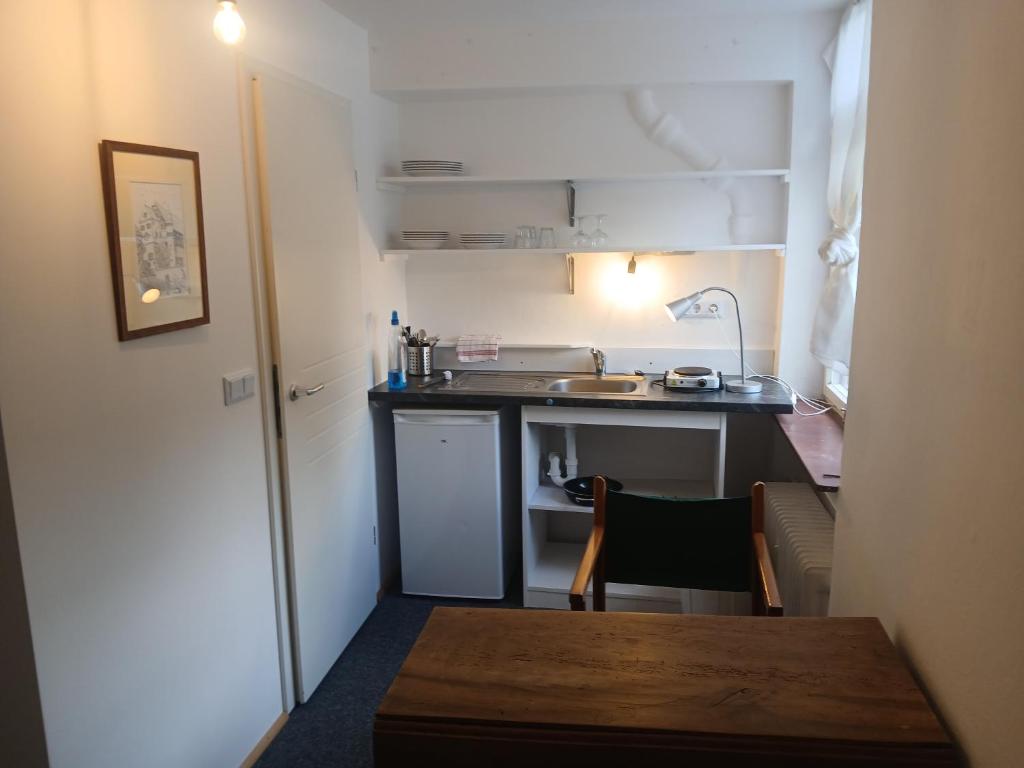 a small kitchen with a sink and a table at Gästewohnung im Schlosshof in Riedlingen