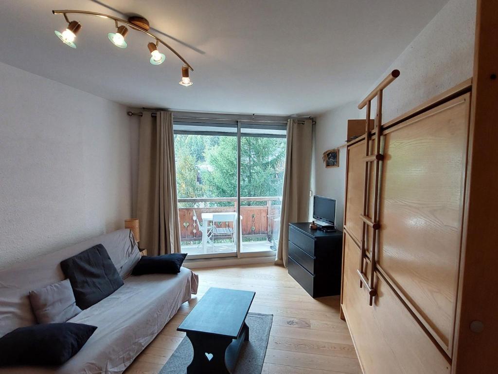 a living room with a couch and a large window at Studio 4 pers avec balcon, au pied des pistes, proche ESF et remontées mécaniques - FR-1-516-193 in Les Deux Alpes