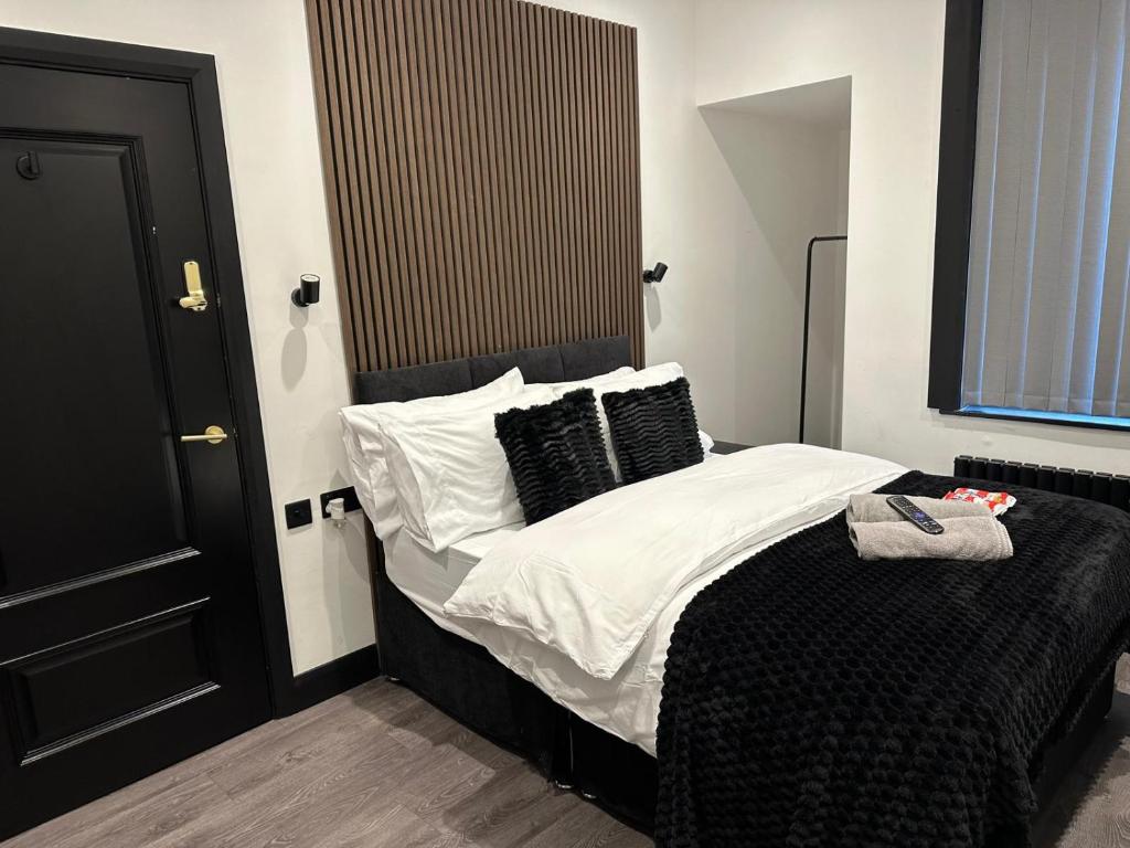una camera da letto con letto e lenzuola e cuscini bianchi e neri di 3M Luxury Living a Preston