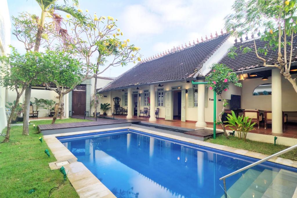 an image of a swimming pool in front of a house at The Dutch Bungalow Seminyak in Seminyak