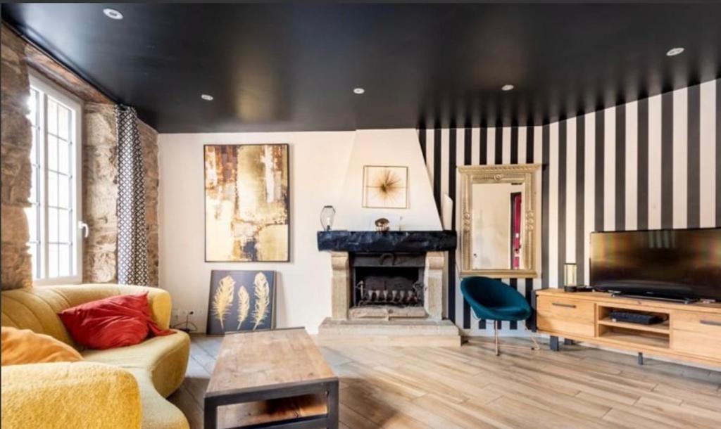 a living room with a couch and a fireplace at Maison de ville in Saint-Pol-de-Léon
