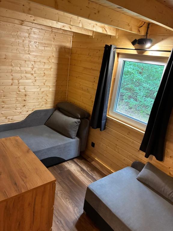 a room with a couch and a window in a cabin at EL PINO - domek w lesie in Skrzynka