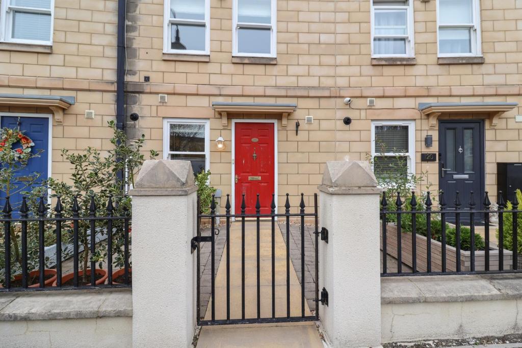a house with a red door and a black fence at Pilgrims Rest in Worle