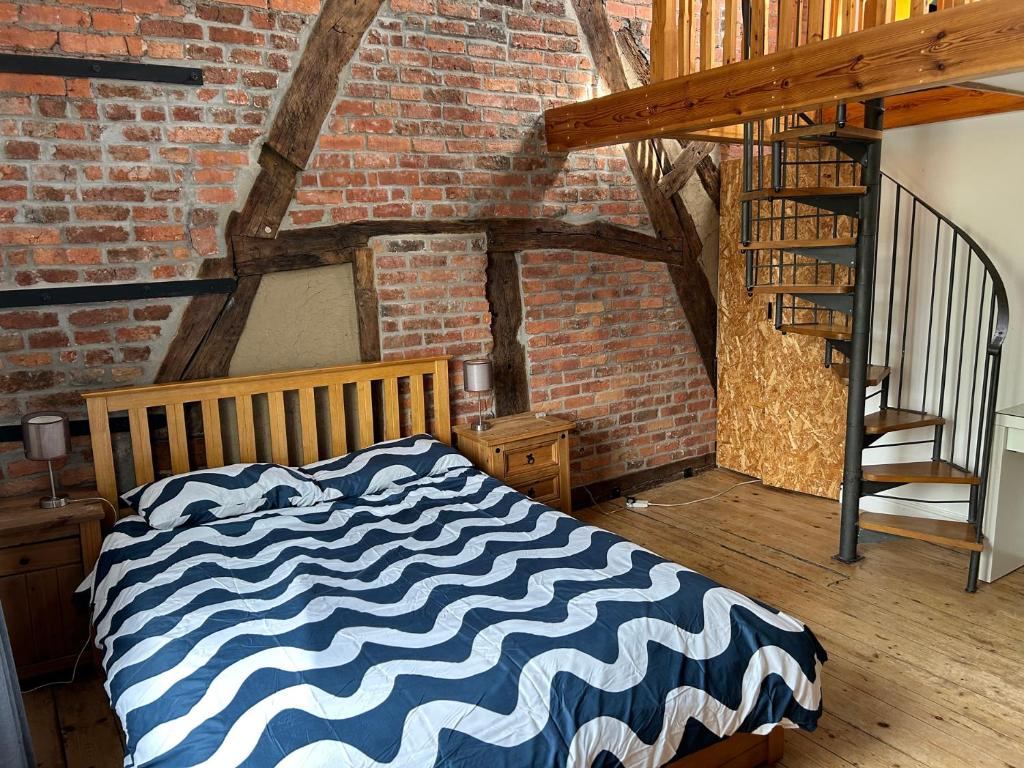 een slaapkamer met een bed en een bakstenen muur bij Mallison Cottage in Stalybridge