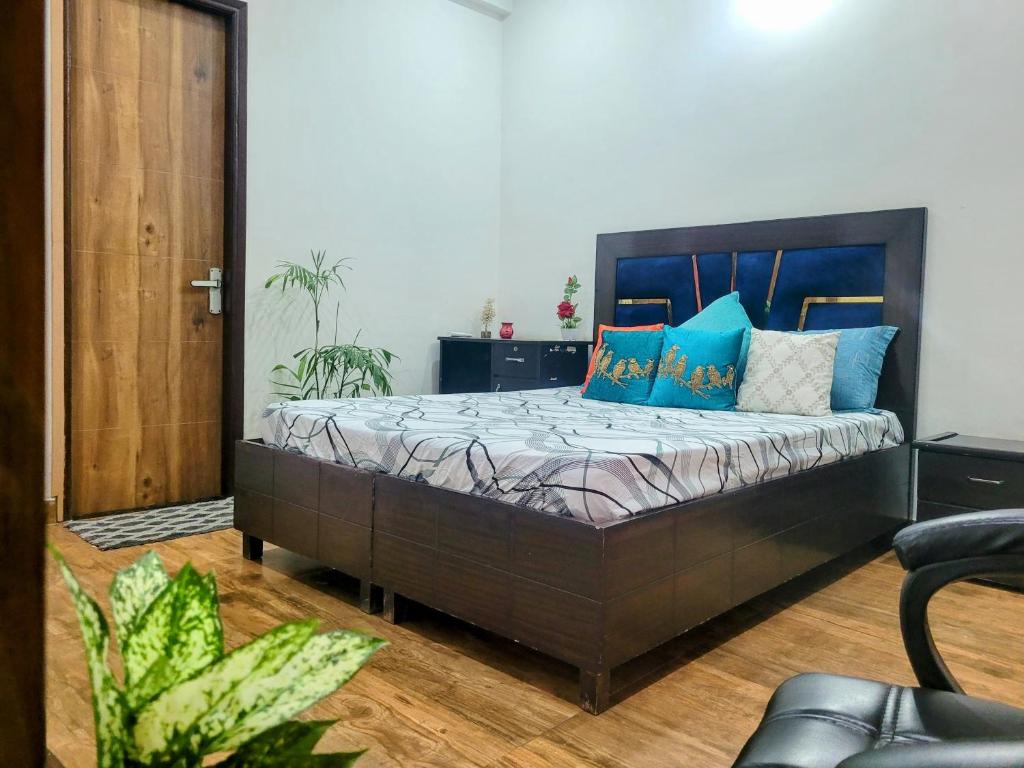 a bedroom with a large bed with blue pillows at Sweethome in Lāndrān