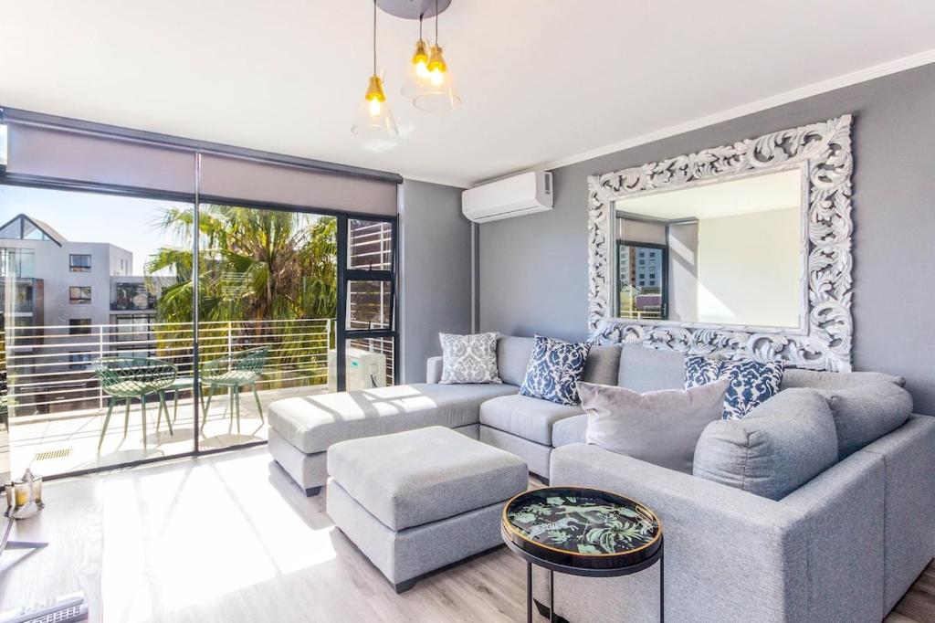 a living room with a couch and a mirror at Quayside 301 by CTHA in Cape Town