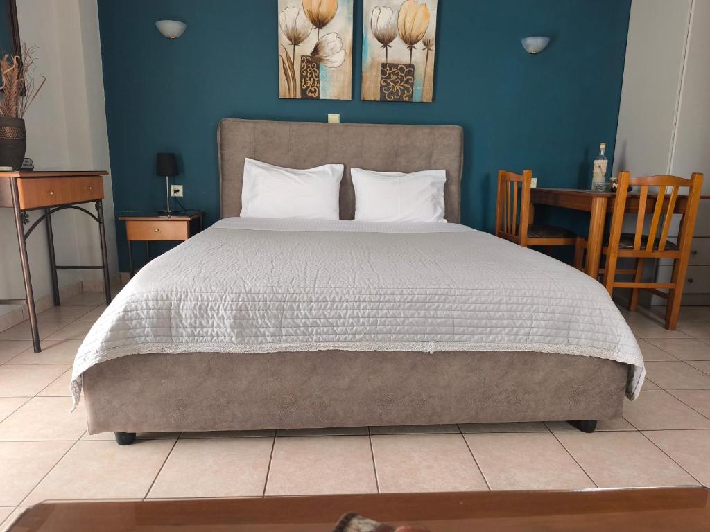 una camera da letto con un letto grande con una parete blu di Zisis Garden Studios a Ioannina